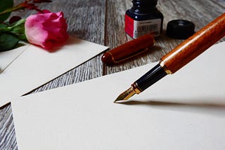 Image of a pen writing on paper.