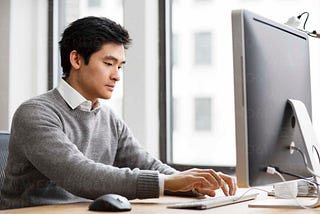 Man Researching on Computer the Average Pay of Life Insurance Professionals