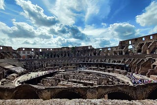 The Colosseum in Rome on a sunny day with blue skies and fluffy white clouds