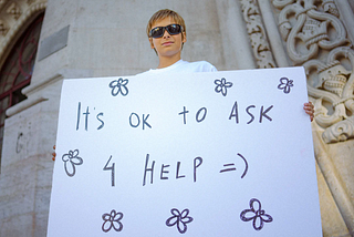 sign reading “It’s ok to ask 4 help :) “