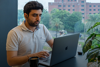 A man working at Daftarkhwan | One, with a view of LUMS.