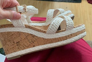 Close up of high wedge heel cream sandals