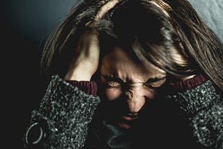 Woman holding her head with angry expression