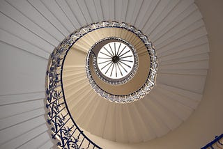 A spiral staircase suggestive of depth as the spiral reaches to roof