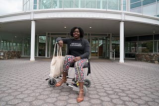 Dark skinned Black woman sitting on a wheelchair