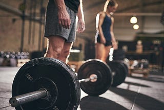 Man and woman going to lift barbells