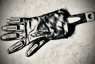 A robotic hand, simulated with a spanner inside a glove, with batteries on each of the fingers and thumb, in black and white. Arty image