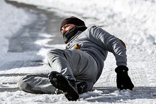 A man slipped on an icy road. He seems in pain.