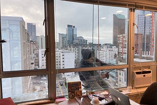 Photo of window washer at work, supported by just two ropes