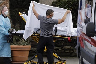 Staff attending to patients at nursing facility. Photo by Elaine Thompson/AP