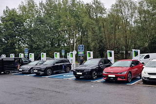 Photo of several electric vehicles lined up at a charging station in a car park