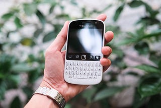 Blackberry phone held in a hand.