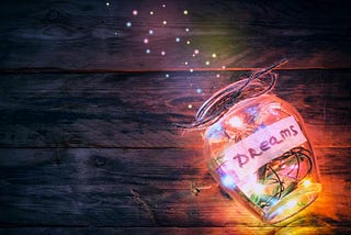 lighted open glass jar with word Dreams