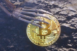 Skeleton hand grasping a bitcoin in a desert