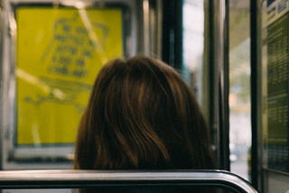 The back of the head of a brunette woman sitting on a bus. Photo by Mathias Reding: https://www.pexels.com/photo/back-of-the-head-of-a-woman-sitting-in-a-bus-9845230/