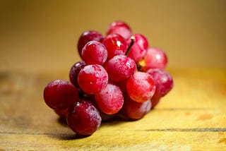 bunch of red grapes on wooden table