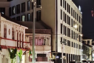 Image of a modern hotel nestled within rows of older heritage buildings.