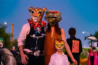 Family with masks of jaguar, Chiricahua leopard frog, and ocelot