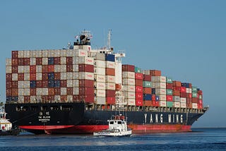A navy blue container ship with the words “YANG MING” on the side.