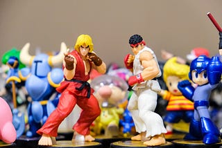 Group of aticulated toys. At the forefront, Ken Masters and Ryu from Street Fighter — both karate practitioners.
