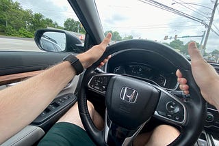 Driving with thumbs up but both hands on the wheel