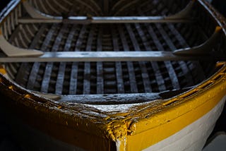 A yellow rowboat, close up. No oars.