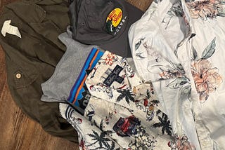 a pile of shirts, a jacket, and a hat