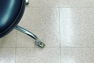 picture of a rolling stool in a hospital exam room.