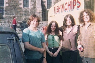 Four 20 year oldstudents outside a chip van