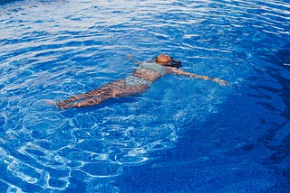 Black woman floating face up in the water