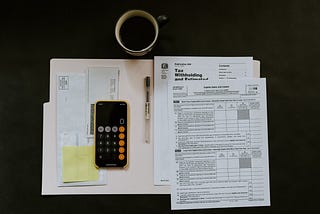 A tax form with a calculator and pen on the left