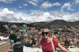 The author standing in front of a view of a Mexican city.