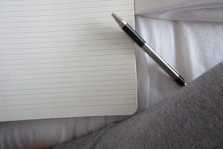A pen and piece of blank lined paper.