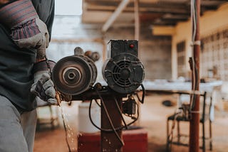 A picture of blacksmith grinding down a tool