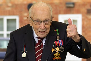 Captain Sir Tom Moore, wearing his war medals, giving a thumbs up gesture
