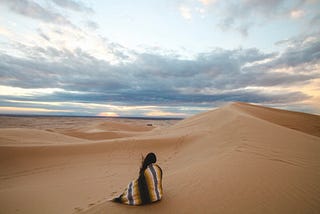 Woman sitting on the sand alone