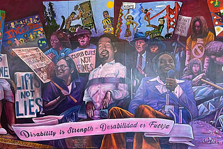 A colorful mural honoring disability rights activists, many using wheelchairs and holding protest signs like “Buses are for Everyone,” “Curb Cuts Not Fines,” and “We Can’t Use Your Stairs.” Scenes of advocacy, protest, and community are depicted, with a pink banner at the bottom reading: “Disability is Strength — Disabilidad es Fuerza.” The mural is credited to artists including D. Paul B., Chris Burch, Vanessa Bravo, and Saria Krdzmar for the Center for Independent Living’s 50th anniversary.