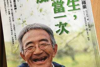 A book cover photo of an old farmer laughing in front of his organic apple orchard.