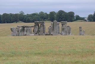 Stonehenge standing stones with King Barrow cemetery mounds in the background.