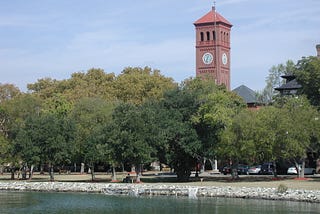 Clock tower and green trees on the waterfront