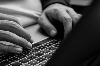 Hands typing on a computer keyboard