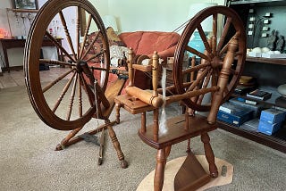 Two treadle spinning wheels sitting in the living room.