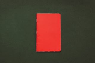 Photo of a red notebook on a green surface