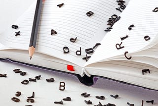 black letters spilling out of notebook, image from DepositPhoto