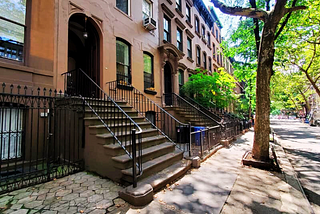 Photo of tree-lined Perry Street with Brownstones