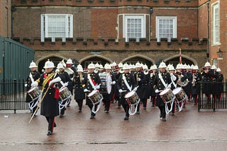 A marching band leaving a building