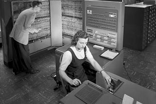 Man and woman working with IBM type 704 electronic data processing machine.