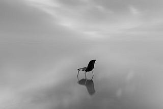 single chair under a dark sky