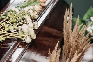 white flowers on wooden coffin