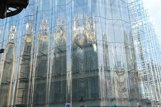 Reflection of city buildings on the side of a building with wavy glass